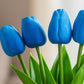 Blue tulips with green stems on a blurred background