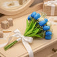 Bouquet of blue tulips with a white ribbon on a wooden surface