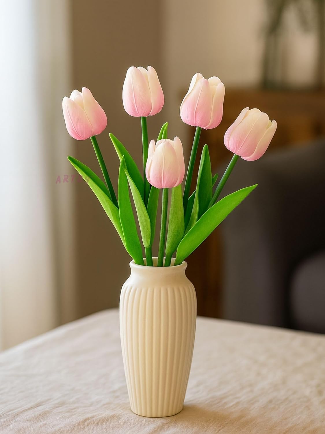 Vase with baby pink tulips on a neutral background