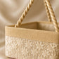 close up of cream decorative basket with floral embroidery and braided handle