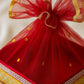 close up of handcrafted red net gift basket with golden detailing